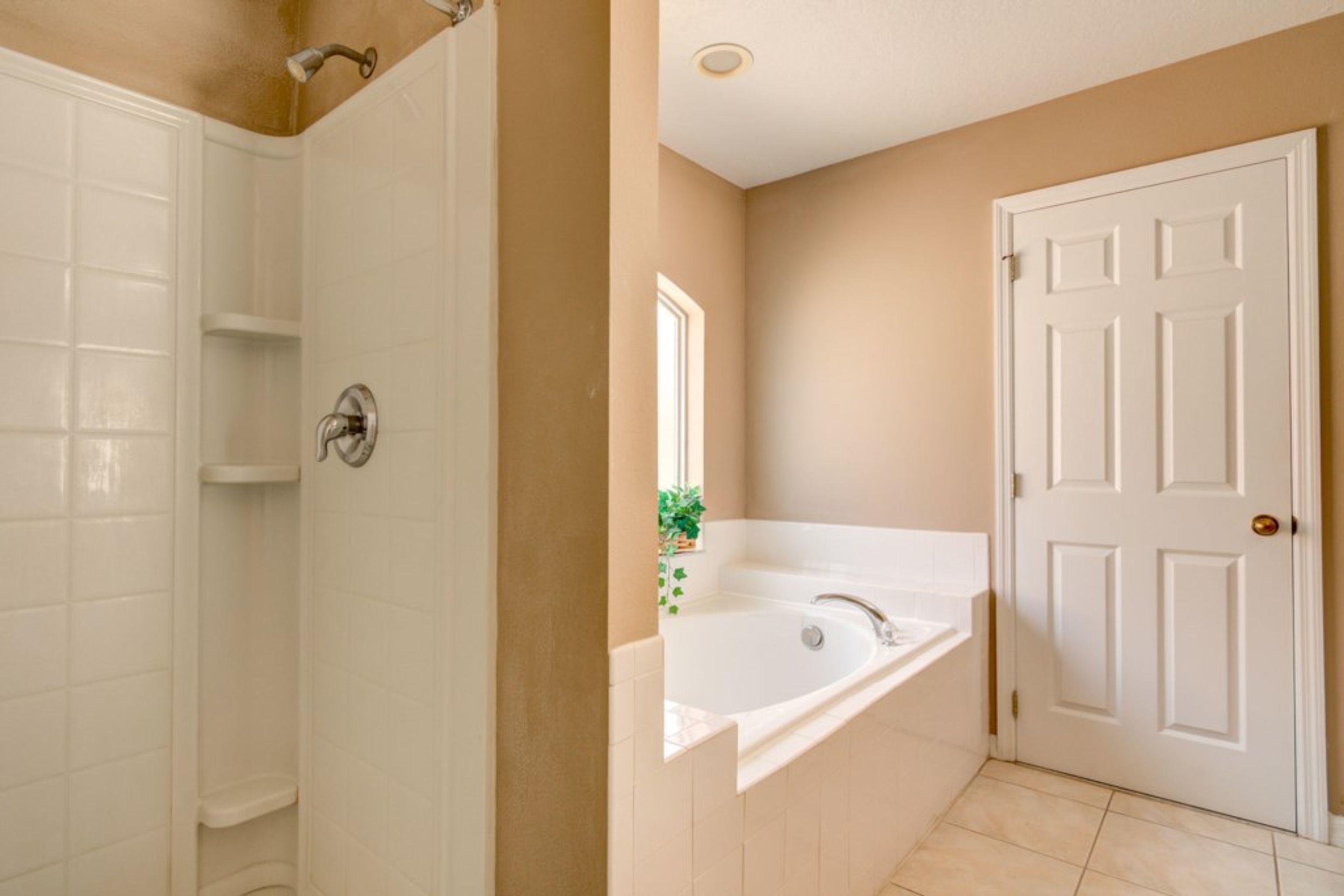 A bathroom with a shower, a bathtub, and a toilet.