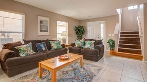 A living room with two brown sofas, a wooden coffee table, and a patterned rug. - Southern Dunes 1120 (Haines City)