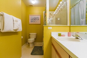 A bathroom with yellow walls, a white sink, and a toilet. - Pinewood Country Estates 714 (Davenport)