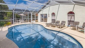 A swimming pool with lounge chairs and a covered patio area. - Lindfields 2952 (Kissimmee)