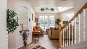A spacious living area with a staircase, a large window, and a door leading to another room. - Calabay Parc 215 (Davenport)