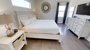 A bedroom with a large bed, a dresser, a television, and a decorative mirror. - Encore Resort at Reunion 7729 (Kissimmee)