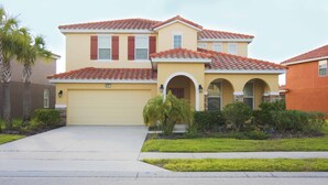 A two-story house with a yellow facade, red-tiled roof, and a garage. - Solterra 4405 (Davenport)