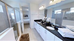 A modern bathroom with two sinks, a large mirror, and a walk-in shower. - Encore Resort at Reunion 7727 (Kissimmee)