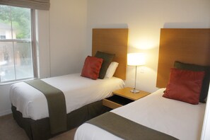 A hotel room with two beds, each with a pillow and a bedside table with a lamp. - Regal Oaks 2776 (Kissimmee)