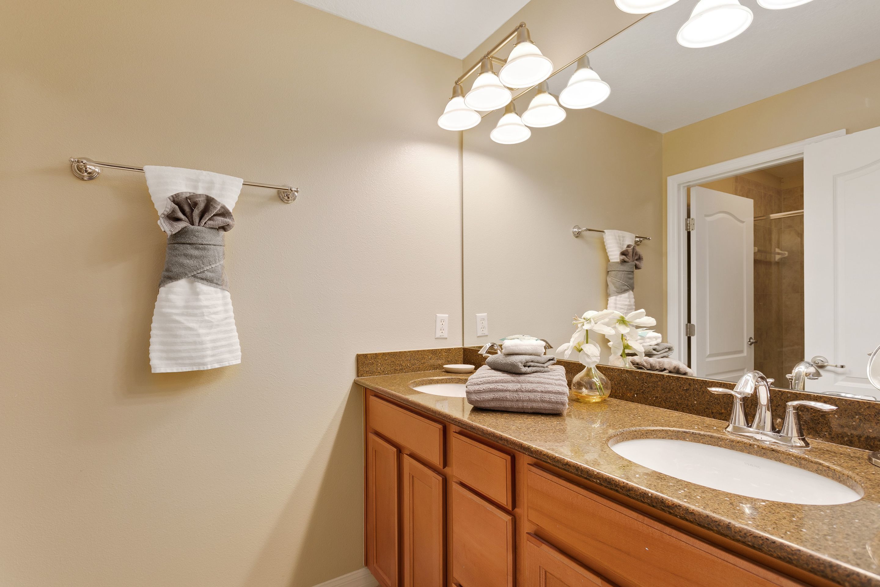 A bathroom with two sinks, a mirror, and a towel rack.
