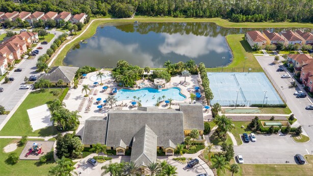 An aerial view of a resort with a swimming pool, tennis courts, and a parking lot. - Paradise Palms 8978 (Kissimmee)