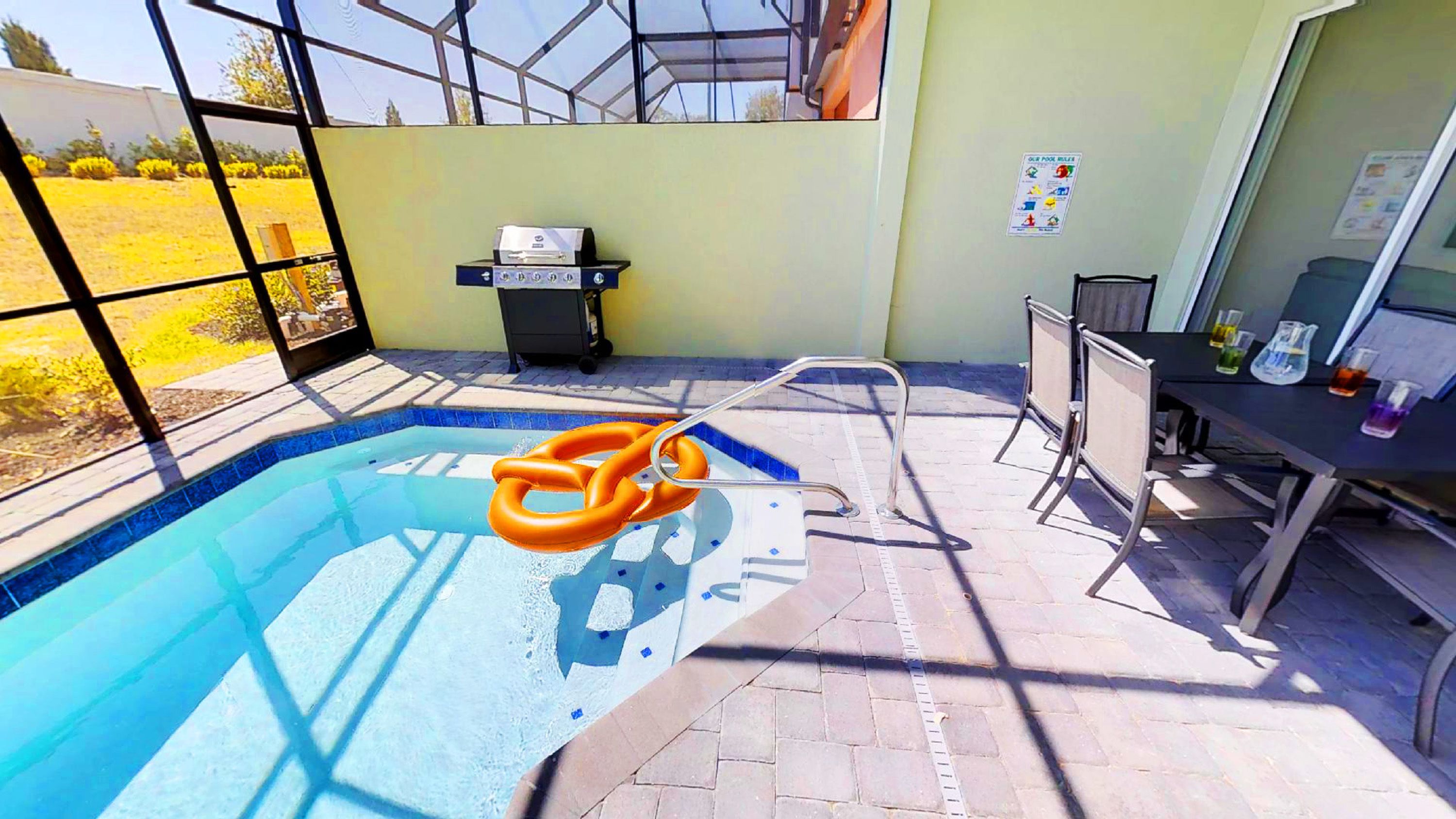 A swimming pool with a ladder, a hot tub, and a table with lab equipment.