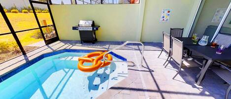 A swimming pool with a ladder, a hot tub, and a table with lab equipment.
