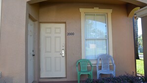 A beige building with a white door, a window with blinds, and the number 2000 on the wall. - Regal Palms Resort & Spa 2000 (Davenport)