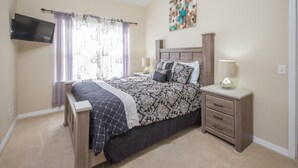 A bedroom with a bed, nightstands, a TV, and a painting on the wall. - Sand Hill 2620 (Davenport)