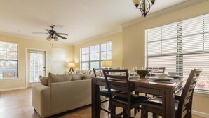 A dining area with a wooden table, chairs, and a ceiling fan. - Bella Piazza 903 - 827 (Davenport)