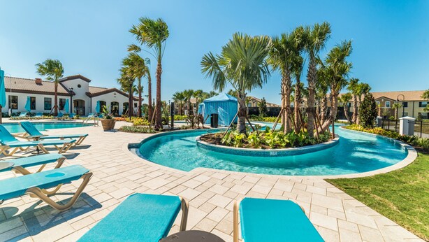A pool area with lounge chairs, palm trees, and a gazebo. - Windsor at Westside 2145 (Kissimmee)