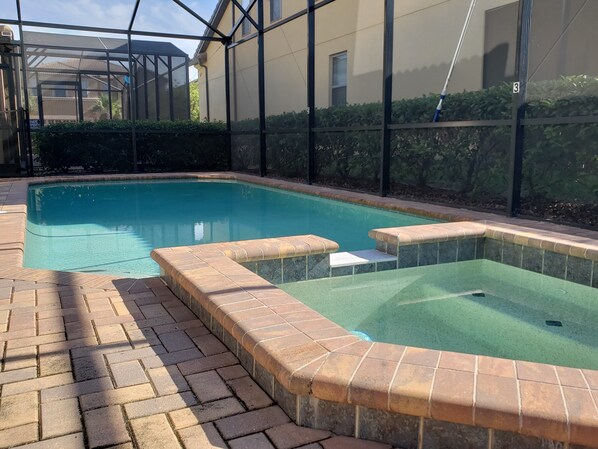 A swimming pool with a tiled deck and a hot tub area. - Windsor at Westside 2145 (Kissimmee)