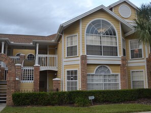 A two-story house with a front porch, a garage, and a small driveway. - Sweetwater Club 2494 - 55 (Kissimmee)