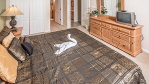 A bedroom with a large bed, a dresser, a television, and a door leading to another room. - Silver Creek 1435 (Clermont)