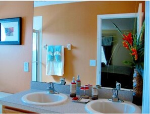 A bathroom with two sinks, a mirror, and a towel rack.