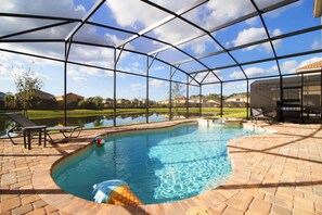 A swimming pool with a covered area, surrounded by a brick patio, and a view of houses in the background. - Golden Palms Vacation Resort 2586 (Kissimmee)