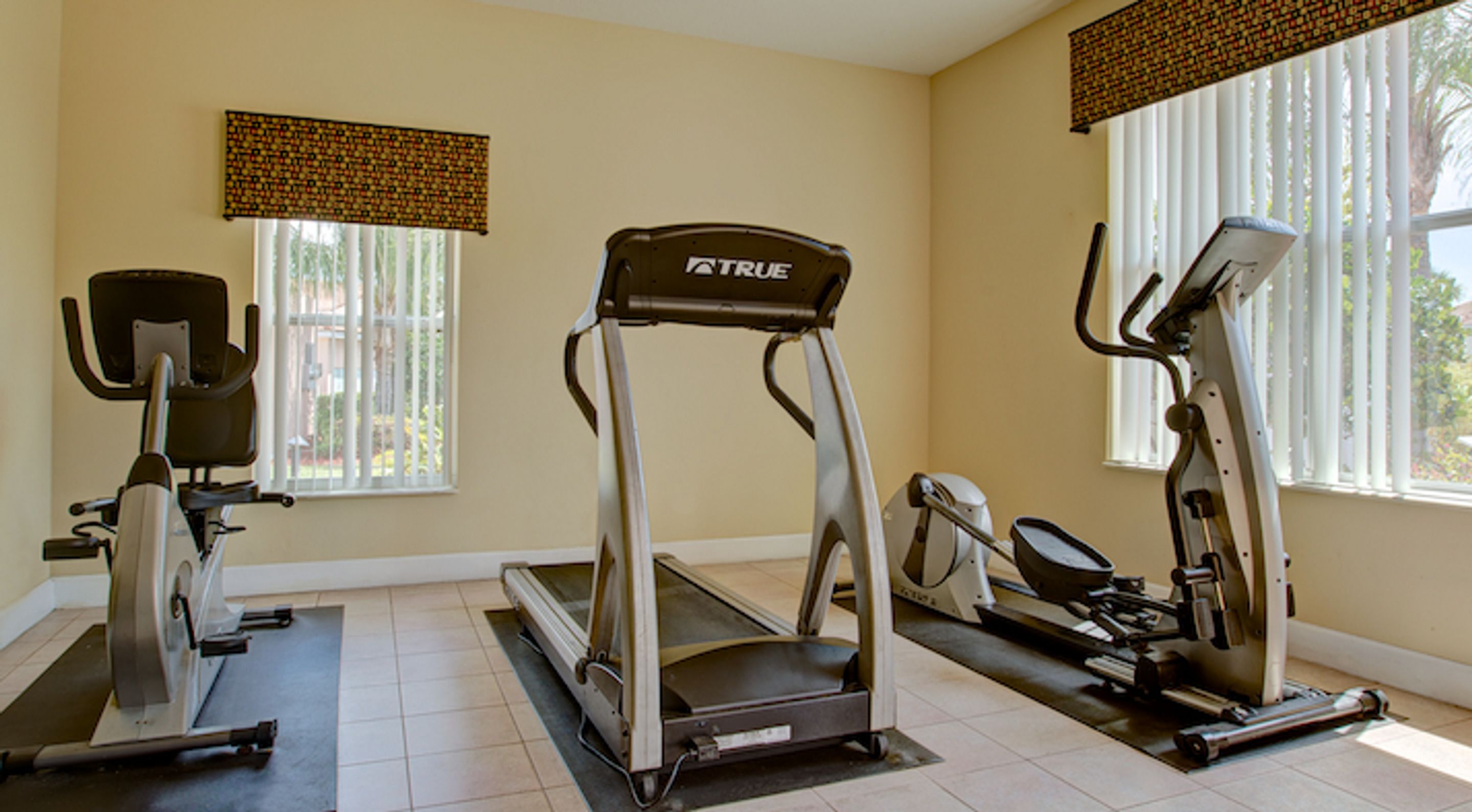 A fitness room with a treadmill, elliptical, and stationary bike.
