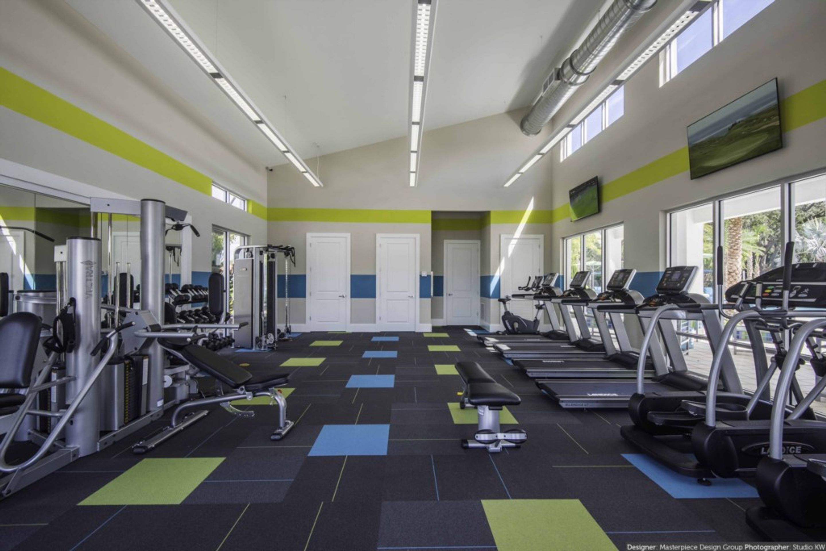 A gym with treadmills, weight machines, and exercise mats.