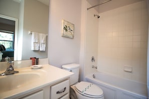 A bathroom with a sink, toilet, and bathtub.