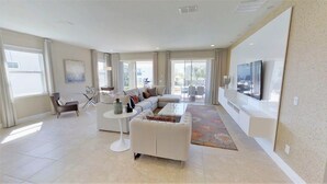 A spacious living room with a large sectional sofa, a coffee table, and a flat-screen TV mounted on the wall. - Encore Resort at Reunion 7632 (Kissimmee)