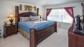 A bedroom with a large bed, two bedside tables with lamps, a dresser, and a television on a stand. - Windsor Hills 2548 (Kissimmee)