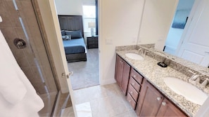 A bathroom with two sinks, a large mirror, and wooden cabinets.