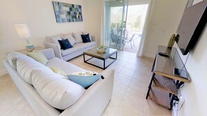 A modern living room with a sofa, coffee table, and a flat-screen TV. - Encore Resort at Reunion 7521 (Kissimmee)