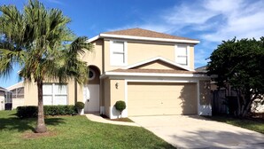 A two-story house with a garage, a covered patio, and a well-maintained lawn. - Chatham Park 2718 (Kissimmee)