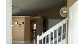 A spacious interior with a staircase, a dining area, and a kitchen visible in the background. - Chatham Park 2718 (Kissimmee)