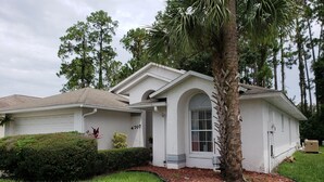 A single-story house with a garage, a covered porch, and a well-maintained lawn.