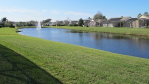 A residential area with a pond, houses, and a fountain. - Country Creek Estate 114 (Kissimmee)