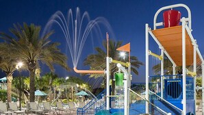 A water park with a water slide, a climbing structure, and palm trees. - Champions Gate 1570 (Davenport)