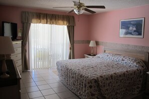 A bedroom with a bed, a ceiling fan, a television, and a window with curtains. - Indian Wells 3120 (Kissimmee)