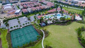 Vista aérea de una zona residencial con cancha de tenis, piscina y club de residentes.