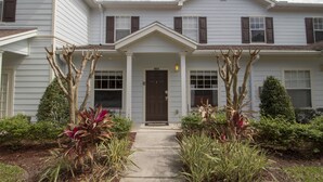 A two-story building with a front porch, a door labeled 'C-100', and a small tree in the center.