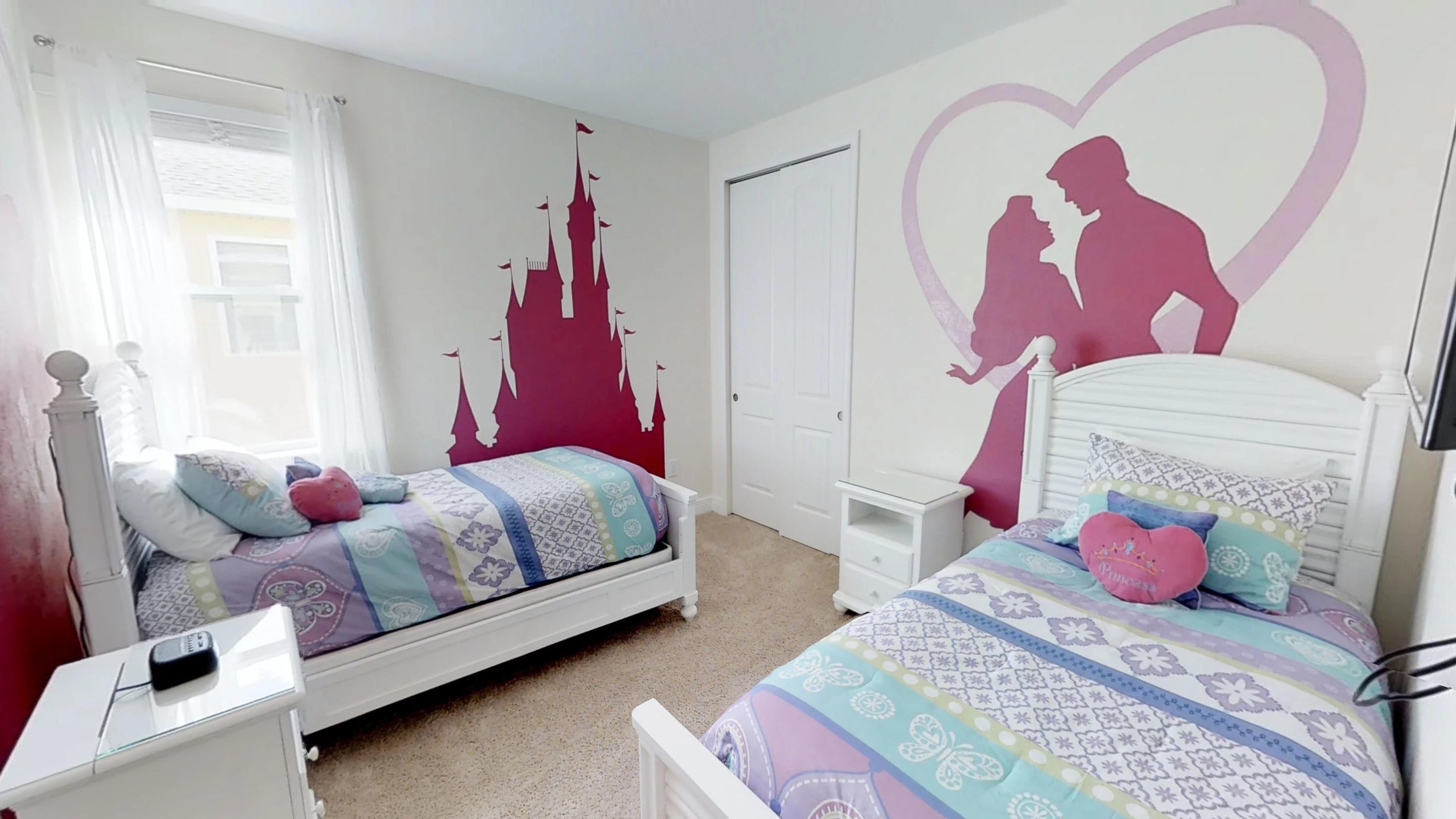 A bedroom with two beds, a wardrobe, and a nightstand.