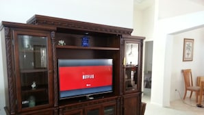 Puisesta materiaalista valmistettu viihdekeskus, jossa on litteänäyttöinen televisio, jonka näytöllä näkyy Netflixin logo.