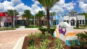 A plaza with a sign for the "Disney Festival" and nearby buildings, including an ice cream shop. - Festival Resort 342 (Davenport)