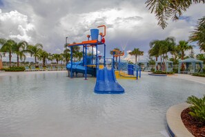 Un parc aquatique avec un toboggan bleu et des aires de jeux.
