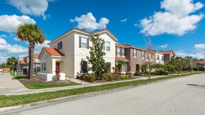 A residential building with a red-tiled roof, multiple windows, and a well-maintained lawn. - Bella Vida 4561 (Kissimmee)