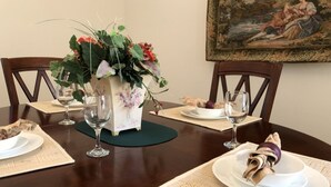 A dining table set with white plates, wine glasses, and a floral centerpiece. - Calabay Parc 410 (Davenport)