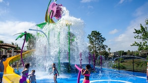 Ein Wasserpark mit einer großen Wassersäule, Rutschen und einem blauen Spielbereich.