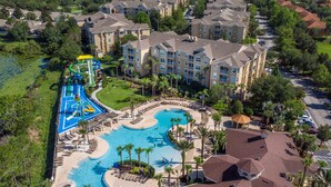 Eine Vogelperspektive zeigt ein Resort mit einem großen Schwimmbecken, einem Wasserpark und mehreren Hotelgebäuden.