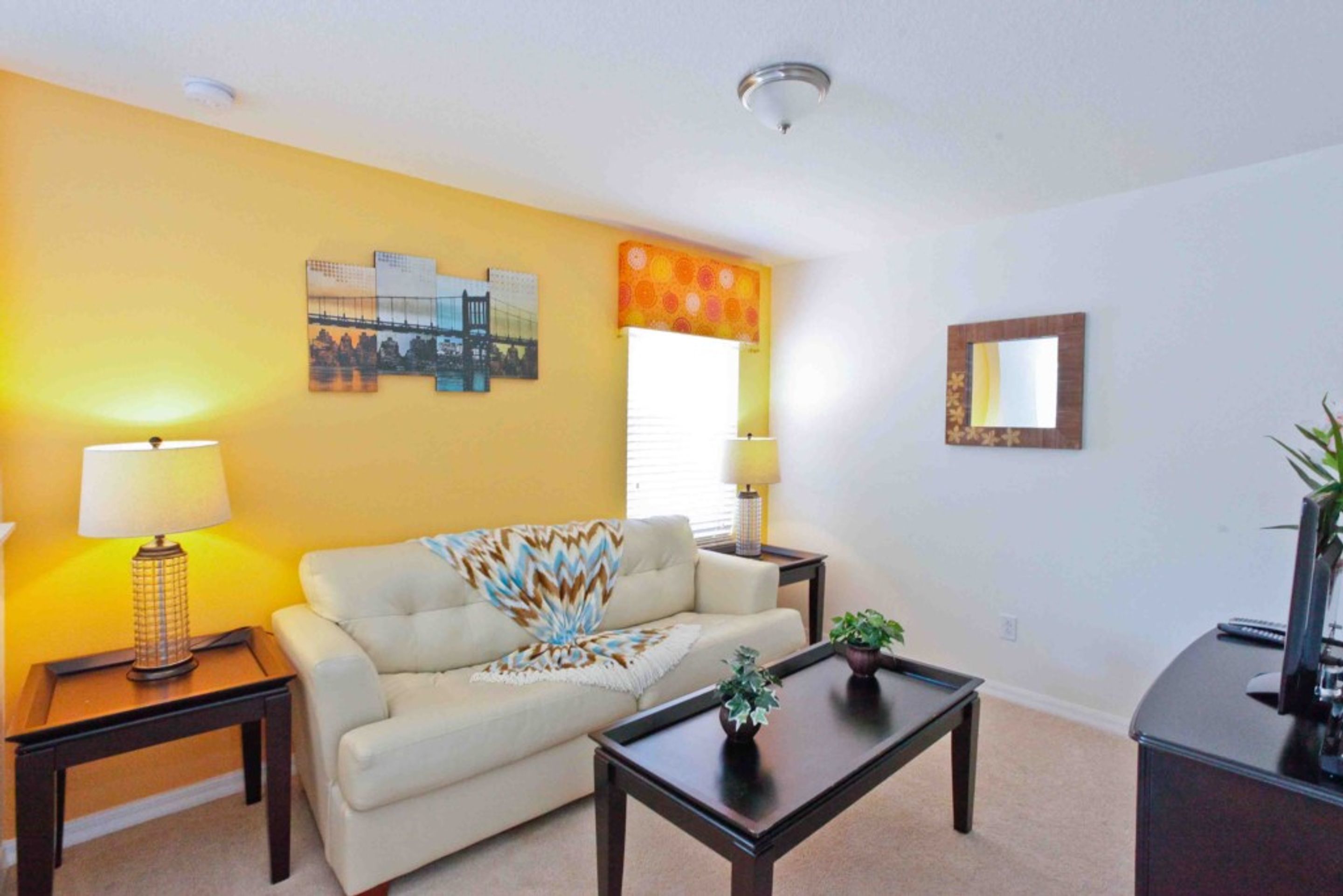A living room with a sofa, two side tables, a coffee table, and a TV stand.
