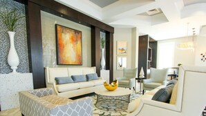 A modern living room with a sofa, armchair, and coffee table. There is a painting on the wall and a vase with plants. - Solterra 4670 (Davenport)