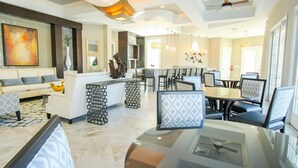 A spacious living area with a sofa, a dining table with chairs, a kitchen area, and a ceiling fan. - Solterra 4670 (Davenport)