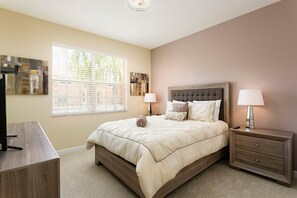 A bedroom with a bed, bedside tables, and a TV stand. - Paradise Palms 2946 (Kissimmee)