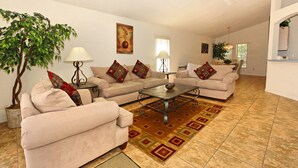A living room with two sofas, a coffee table, a lamp, and a potted plant. - Highlands Reserve Golf & Country Club 301 (Davenport)
